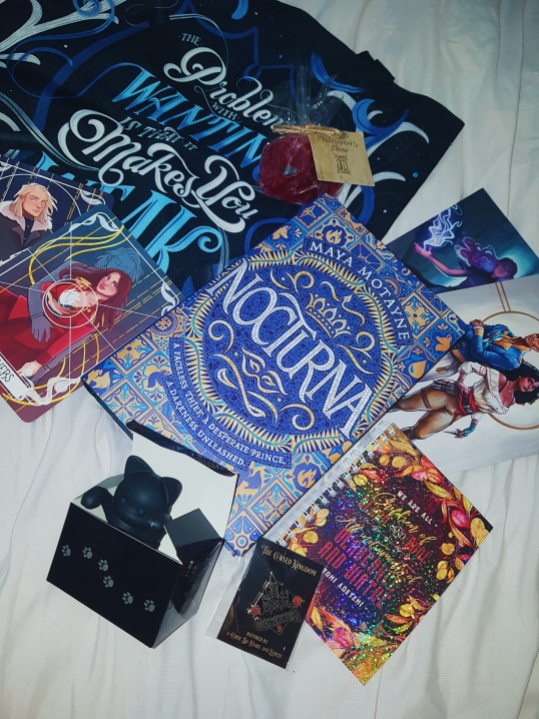 Fairyloot April Dark Magic unboxing photograph - features leigh bardugo (tote bag) and jay kristoff (black cat tea strainer) inspired merch, along with a philosophers stone soap.